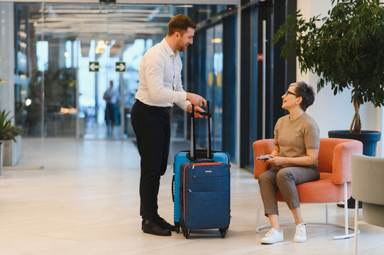 Bellboy helping hotel guest with luggage in lobby