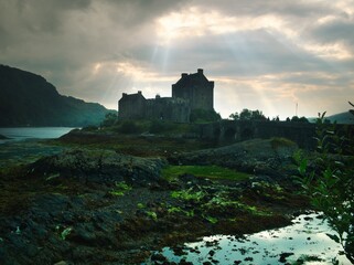 Eilean donan castle with sunbeams piercing dark clouds © jacopo