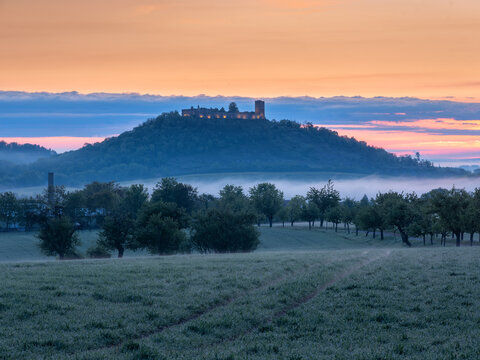 Ausblick auf die Ruine der Burg Gleichen in der Morgend&auml;mmerung bei Nebel und Morgenrot 