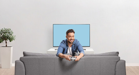 Man holding a joystick and playing games on a tv screen © Ljupco Smokovski