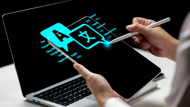 A person uses a stylus on a tablet showing a glowing translation icon interface next to a laptop