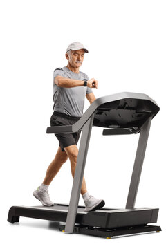 Senior man walking on a treadmill and checking his smartwatch