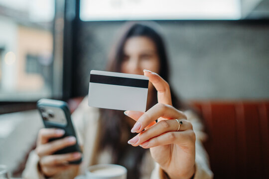 Woman holding credit card and smartphone for online payment transaction