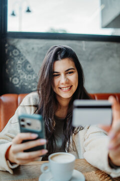 Woman happy using credit card for online payment on phone