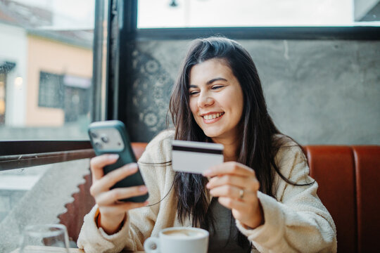 Woman making online payment with credit card and smartphone