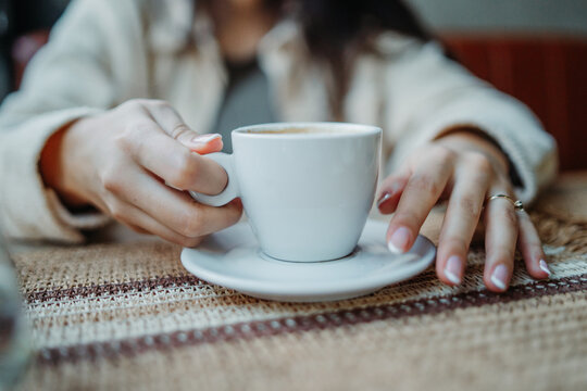 Woman hands holding coffee cup enjoying morning beverage