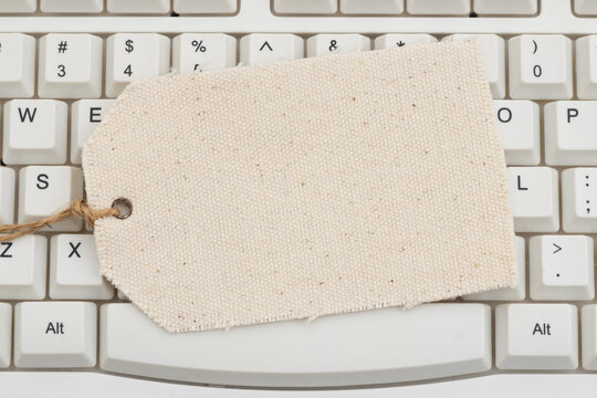 Blank price tag on a white computer keyboard for e-commerce sales and discounts