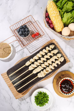 Handmade Gluten-Free Dumpling Skewers with Fresh Vegetables and Dipping Sauce on Marble Background