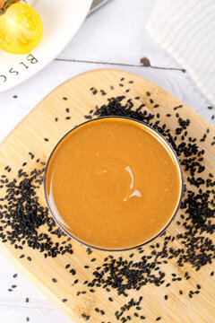 Traditional Chinese Sesame Sauce with Black Sesame Seeds on Wooden Board - Asian Condiment