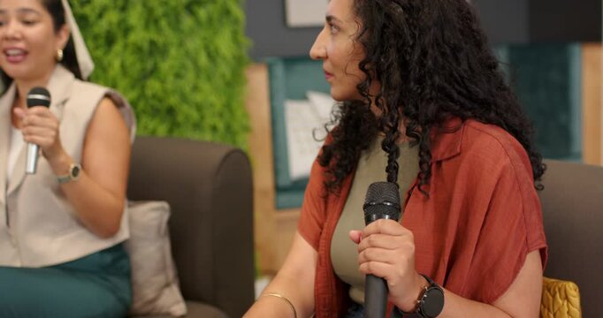 Adult Asian woman in beige blazer speaking into mic on sofa, camera shifting, revealing AI slide