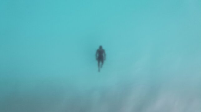 Scuba Diver Swimming Alone in Turquoise Ocean Water