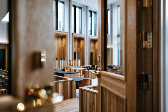 A modern courthouse interior showcasing sleek wooden elements, abundant natural light, and a professional atmosphere designed for legal proceedings and justice.