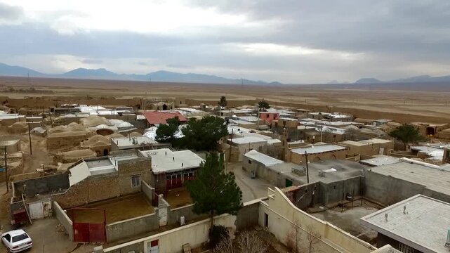 Fascinating wide-angle drone view tracking an ancient clay castle fortification and mud brick fortress ruins inside a traditional desert village settlement, revealing historic heritage style.
