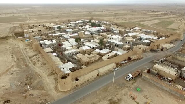 Breathtaking high-angle drone view of an expansive mud brick castle fort complex in a remote desert village province, showcasing historical clay architecture and aged heritage design.