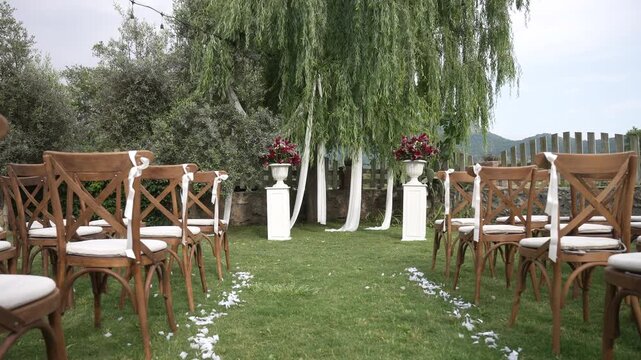 Elegant wedding ceremony setup with empty chairs on a green lawn before the event begins ,fa01