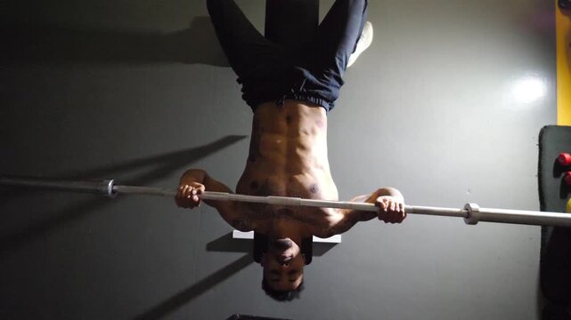 Muscular african man doing bench press workout with a barbell at sport club. Young afro american sportsman doing weightlifting exercises at modern gym. Healthy and active lifestyle concept. Top view