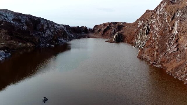 Incredible high-angle drone capture of a majestic salt dome structure with an inner crystal pond, highlighting the vivid contrasts between white mineral crusts and dark water bodies video.