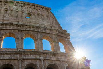 Obraz premium Famous Coliseum in Rome. Colosseum, or Coliseum. Sunset at huge Roman amphitheatre, Rome, Italy, Europe. Famous touristic place in the world and Europe. Beautiful blue sky background.