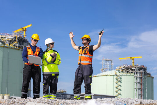 Industrial engineers team working and communicating at oil refinery plant, Supervisors managing operations at oil and gas facility, Worker team in safety gear discussing project at industrial site