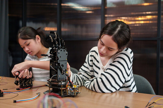 Students assemble a robotic arm in a STEM classroom, developing engineering, coding, teamwork, and problem-solving skills through hands-on technology learning.