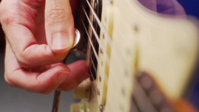 Close-Up of Playing Electric Guitar with a Coin Instead of a Traditional Pick