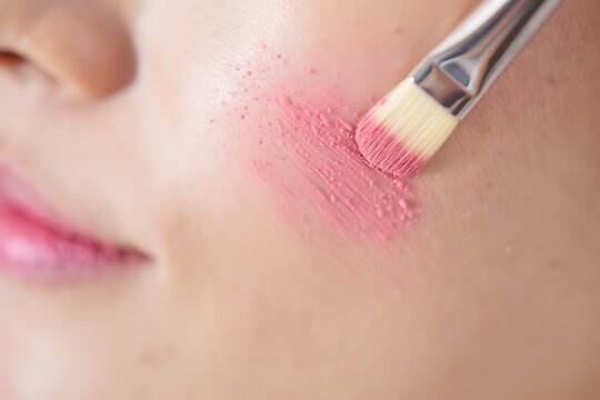 Applying lipstick with makeup brush close-up