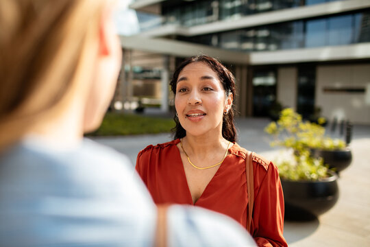 Two businesswomen having conversation outside office building