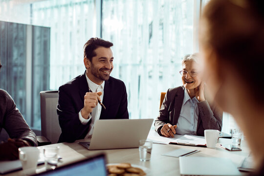 Smiling colleagues in a business meeting at modern office boardroom