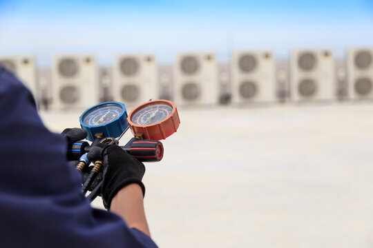 Technician is checking air conditioner ,measuring equipment for filling air conditioners.