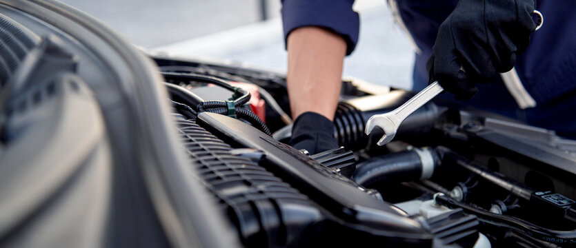 Professional mechanic working on the engine , repairing a car engine automotive workshop with a wrench, car service and maintenance,Repair service.