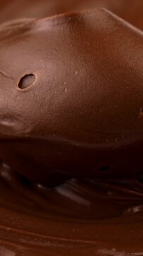 Spoon spreading and taking brown creamy melted milk chocolate spread close up, vertical video