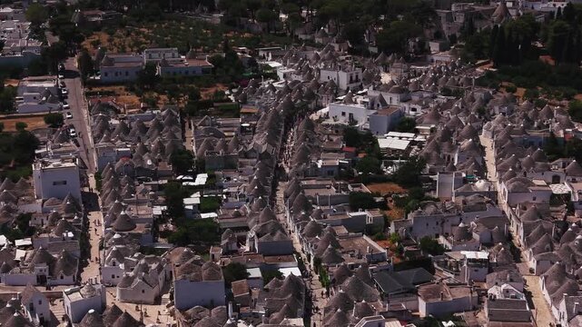 Aerial view flying over the famous trulli of alberobello, a unesco world heritage site with traditional apulian dry stone huts with a conical roof in puglia, italy