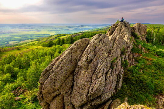a young handsome man travels through the mountains of the Southern Urals on a summer day