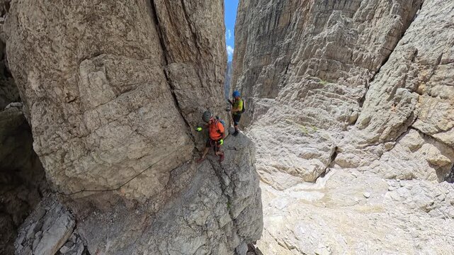 Two Hikers Walking Along an Exposed Ledge Below Campanile Basso on Via Ferrata Bocchette Centrali