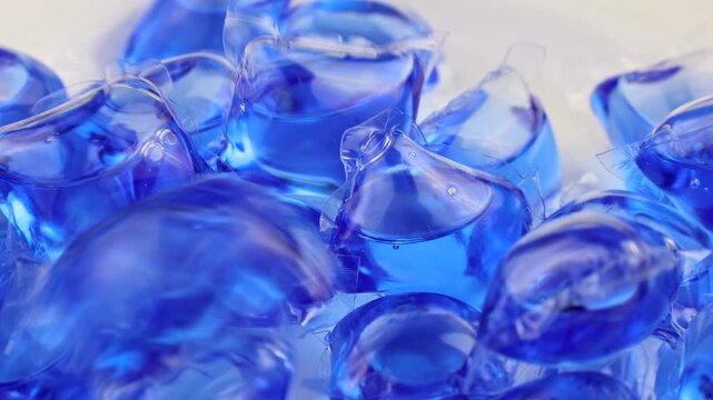 Blue laundry detergent pods or liquitabs for washing machine falling down close up