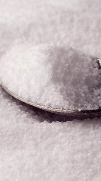 White natural organic sweet Sorbitol sweetener granules taking with a spoon close up. Sugar substitute concept, vertical video format
