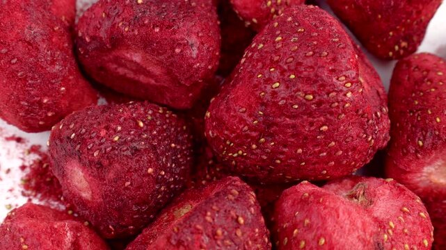 Red whole freeze dried strawberry berries circle rotation close up