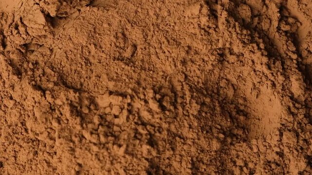 Slow motion sprinkle of aromatic cacao powder creating dusty texture