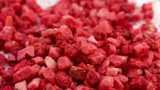 Red freeze dried strawberry slices falling down close up