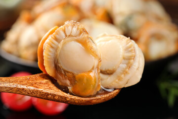 Obraz premium Fresh Shucked Scallops from Qingdao on Wooden Spoon - Raw Seafood Meat Without Shells