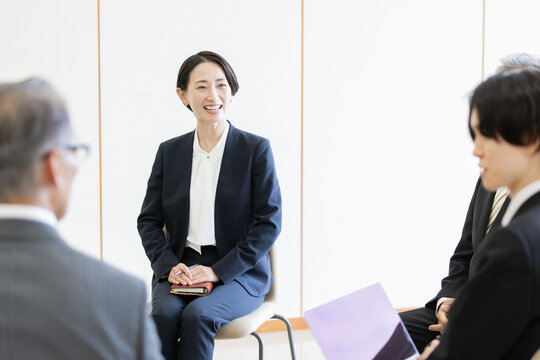 ビジネスミーティングで意見交換をする多世代のビジネスチーム