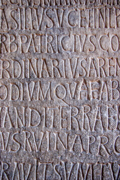 Ancient Latin inscription carved in stone. Close up detail of chiseled Roman letters on historic epigraph tablet.