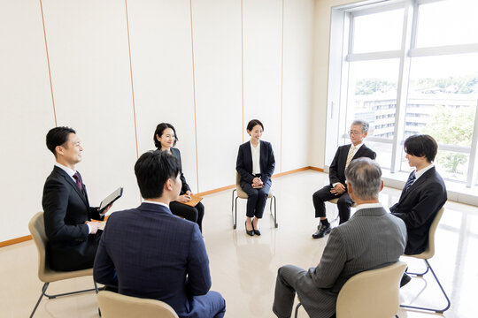 ビジネスミーティングで意見交換をする多世代のビジネスチーム