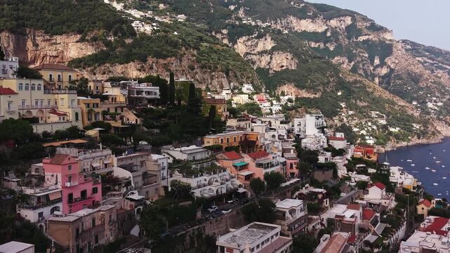 Scenic aerial view revealing the charming coastal village of positano on the amalfi coast with its colorful houses, steep cliffs, and mediterranean sea with boats