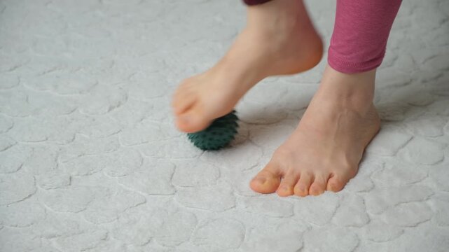 Woman Rolling Spiky Massage Ball Under Foot for Plantar Fascia Relief