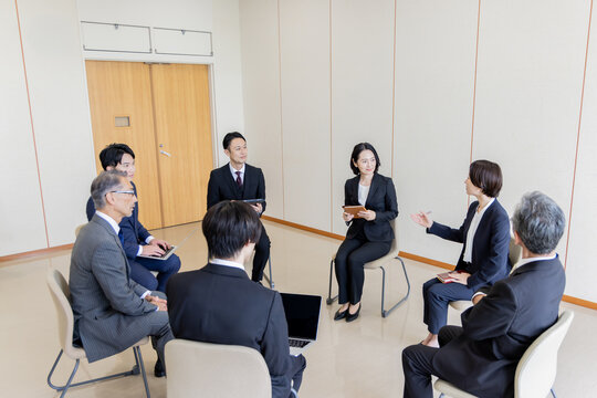 ビジネスミーティングで意見交換をする多世代のビジネスチーム