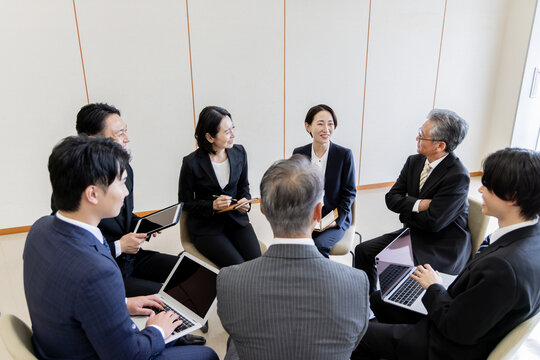 ビジネスミーティングで意見交換をする多世代のビジネスチーム