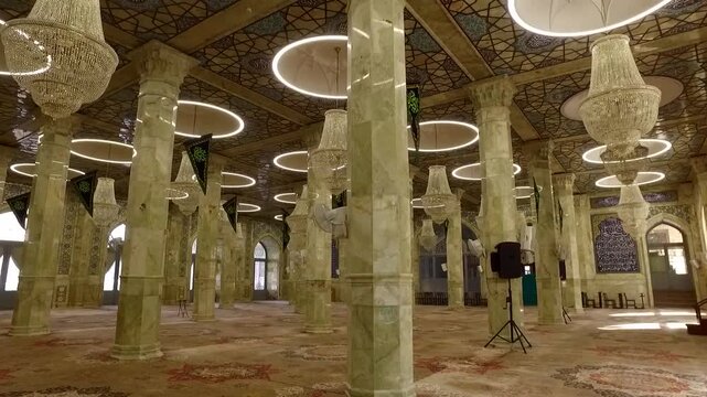 Long hall with tall columns inside historic mosque under natural light showing Islamic architecture and geometric patterns.