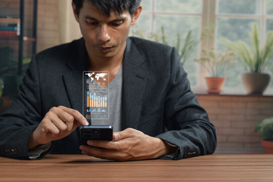 Businessman Using Smartphone with Digital Charts and Graphs in Modern Office