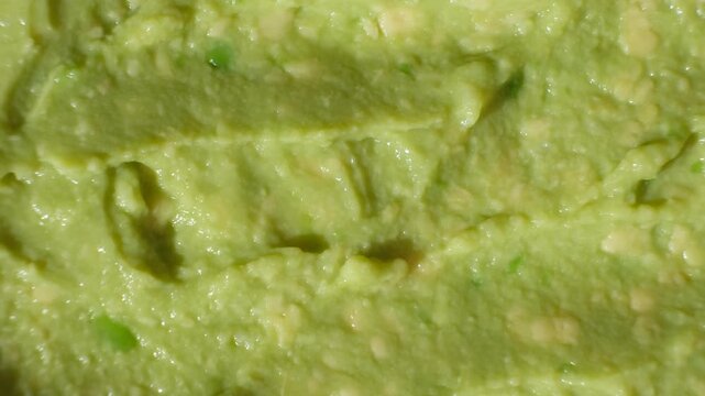 Top view rotating of healthy organic avocado puree structure.